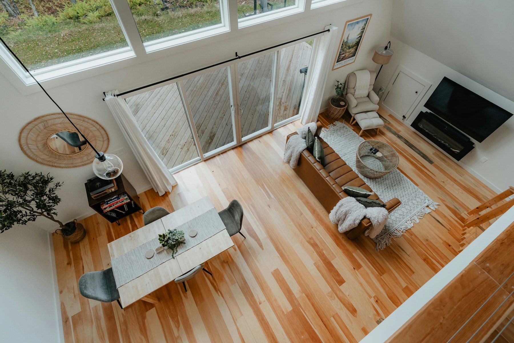 Bright open living and dining area with light wood floors, seen from above