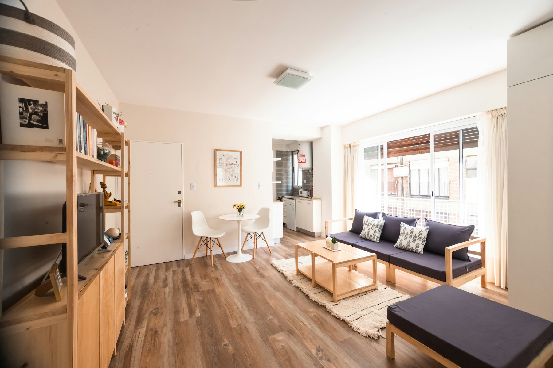 Living room with wood-look plank flooring and a navy sofa