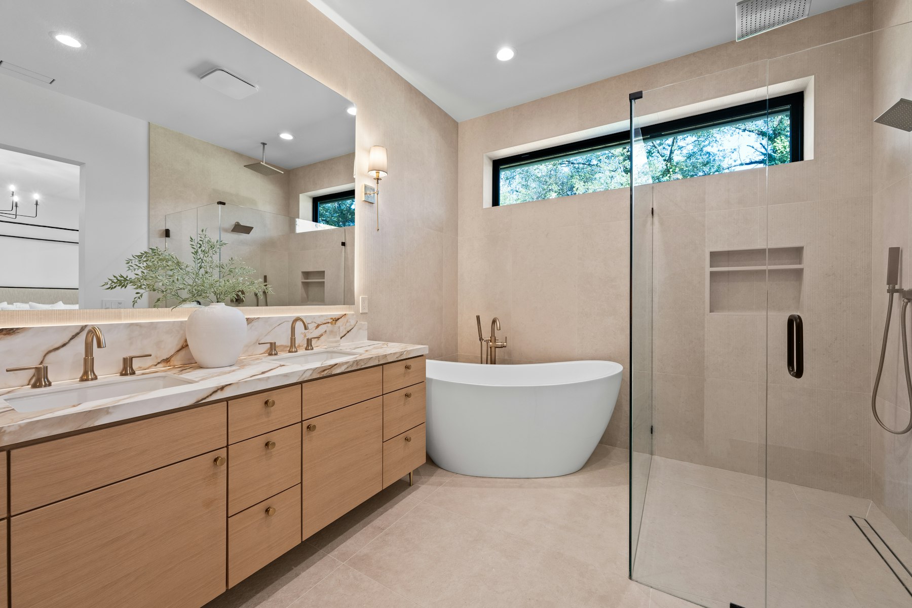 Bathroom with a freestanding tub, a glass shower and a double vanity